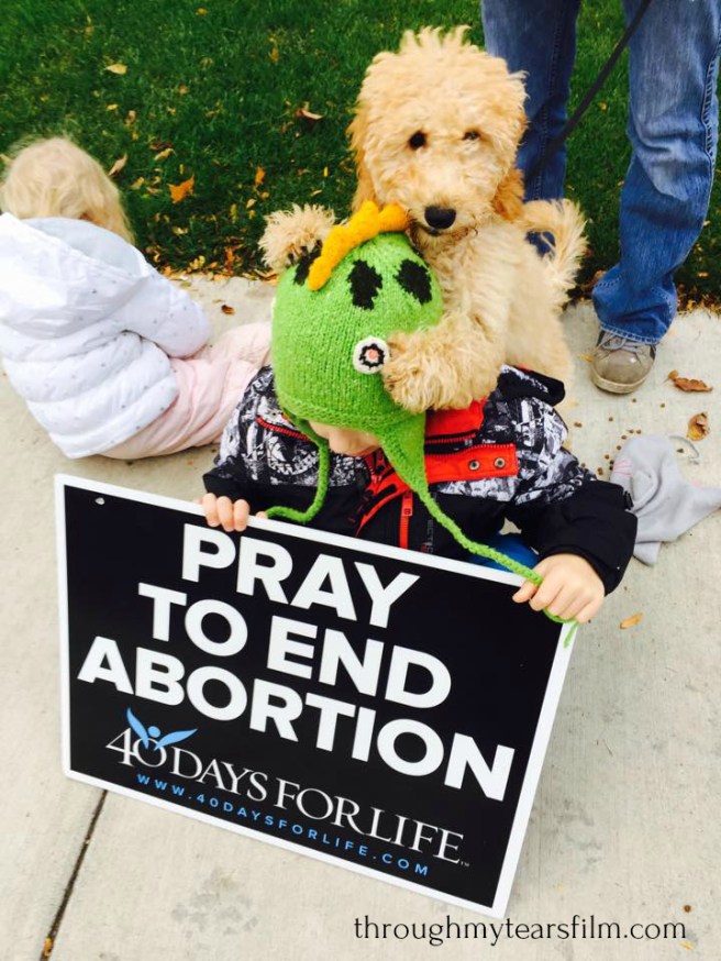 Buttercup chewing Isaac's hat outside Heritage Clinic for Women